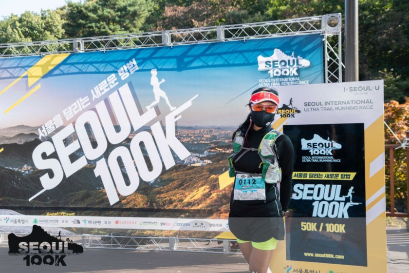 SEOUL 100K 간판에 서있는 여자 이미지