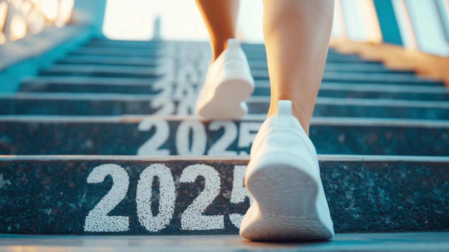 2025 표시가 된 계단을 오르는 사람